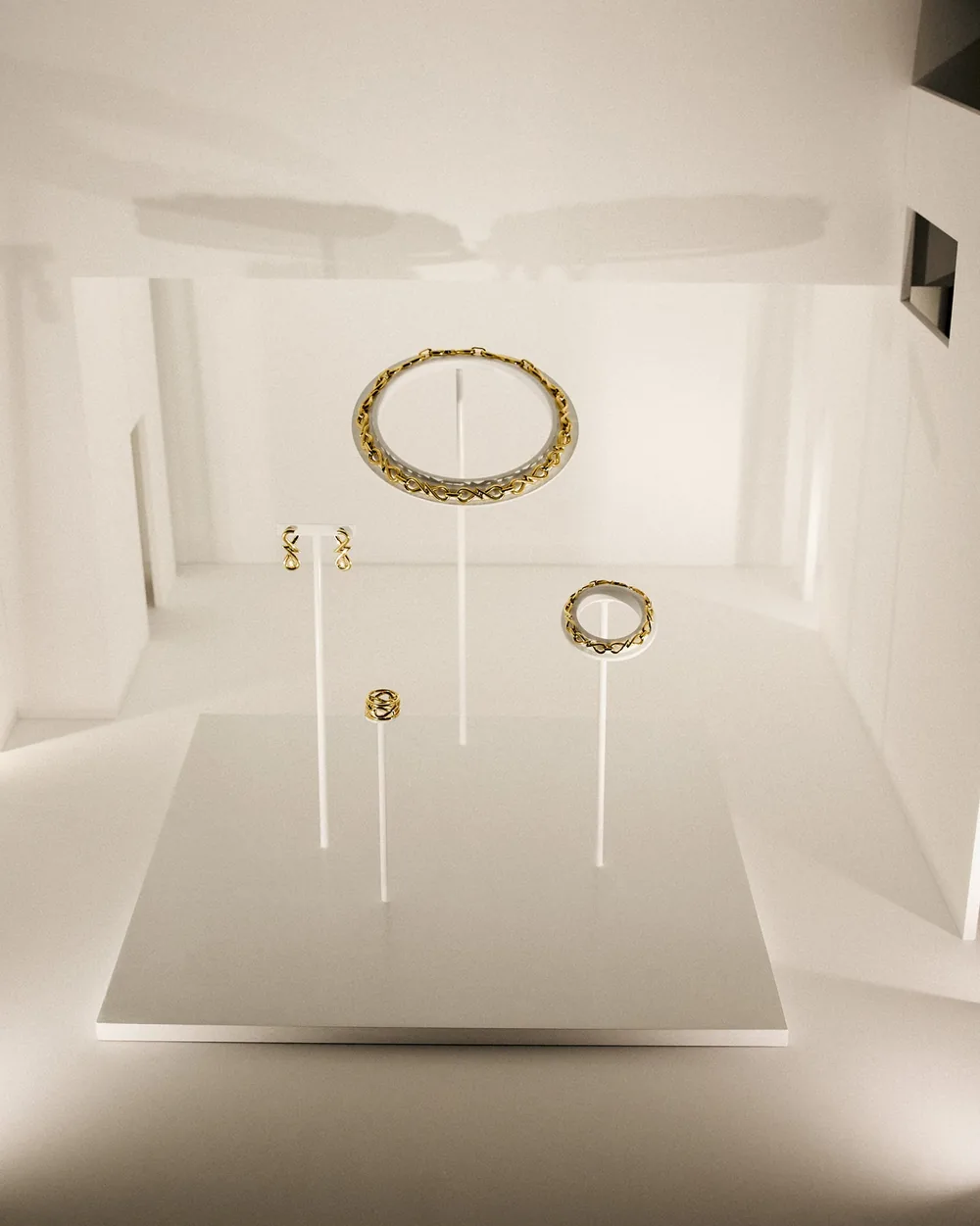 Collar, anillos y pendientes de oro de Suarez sobre soportes blancos en la exposición